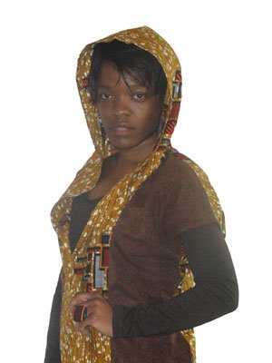 AfriBloom hooded cape front view in wax fabric African wax cape with extended hood – side view Handmade Afro-fusion cape – model wearing brown and gold wax