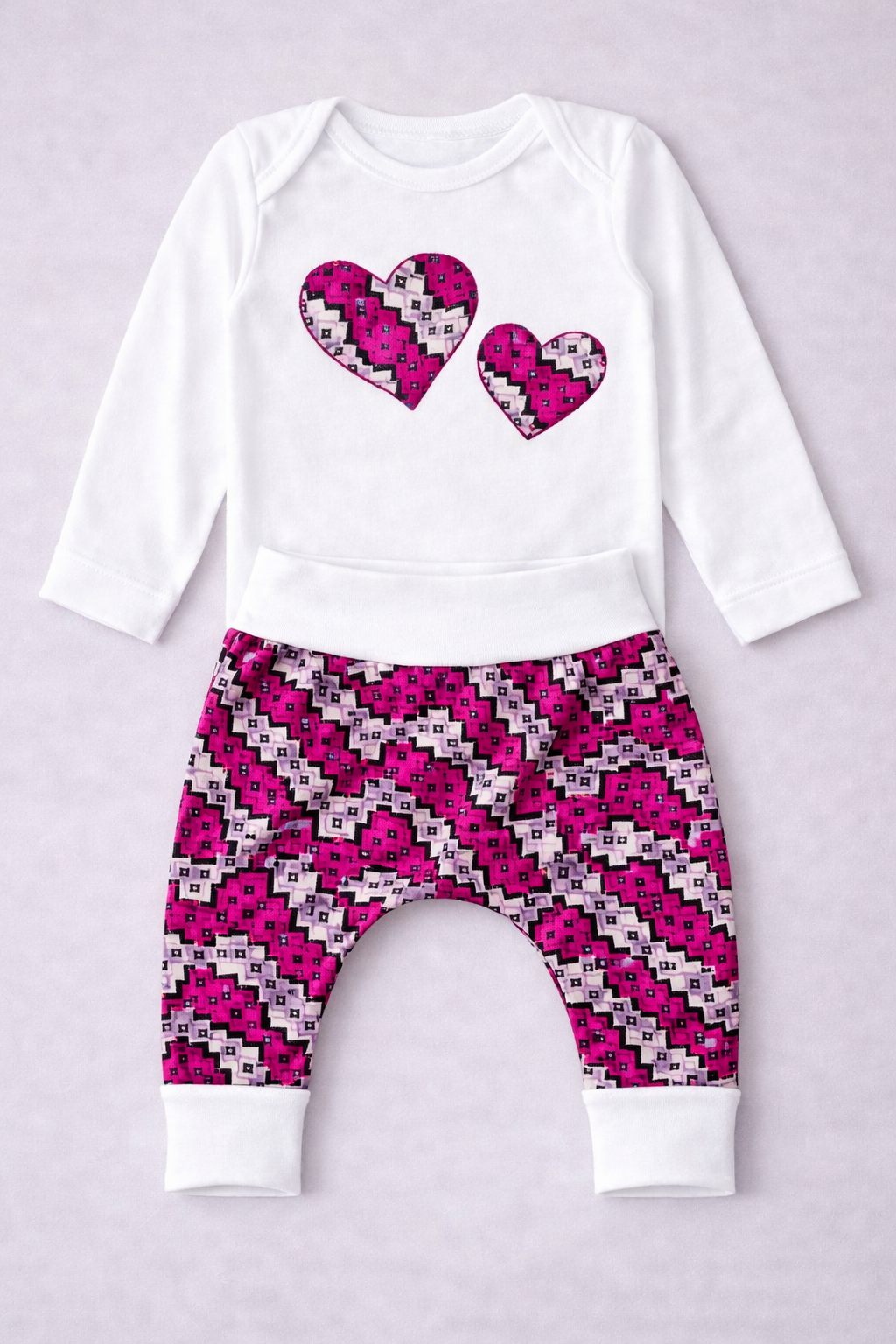 White cotton baby onesie with heart appliqué and wax harem pants set