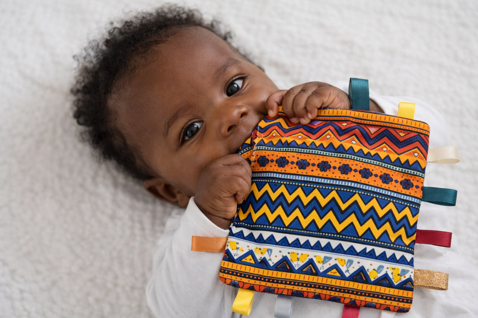 African baby holding and chewing AfriBloom crinkle sensory baby toy
