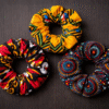 AfriBloom African wax scrunchies set of 3, handmade colorful hair accessories on dark background