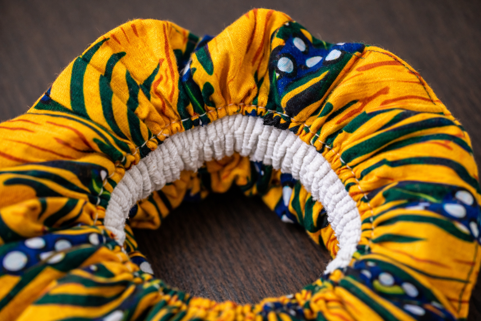 Close-up of handmade African wax scrunchie showing strong elastic and premium stitching, AfriBloom quality detail