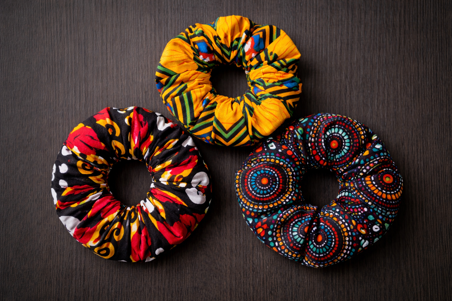 AfriBloom African wax scrunchies set of 3, handmade colorful hair accessories on dark background