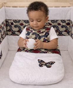 African print newborn crib set with handmade crib bumper, sleeping bag and organizer, baby sitting safely in crib