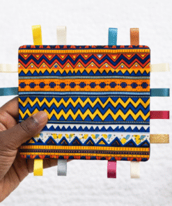 AfriBloom crinkle sensory baby toy held in an adult hand to show size, handmade with African wax fabric and ribbon tags