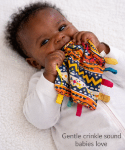 Baby enjoying AfriBloom crinkle sensory toy during playtime on soft bedding