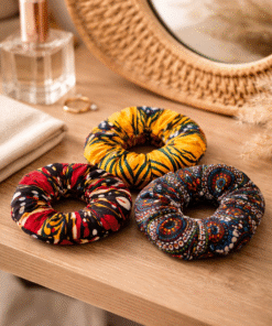 African wax scrunchies set styled on vanity table, handmade AfriBloom hair accessories in vibrant prints