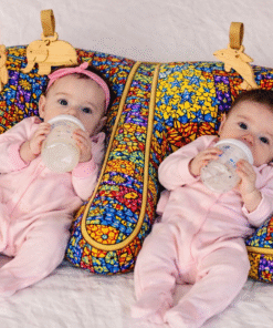 Two newborn babies feeding while resting on a handmade African patchwork double baby support pillow, twin infant lounging pillow by AfriBloom