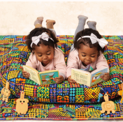 Two toddlers reading together on a handmade African patchwork double baby support pillow, shared infant lounging cushion by AfriBloom