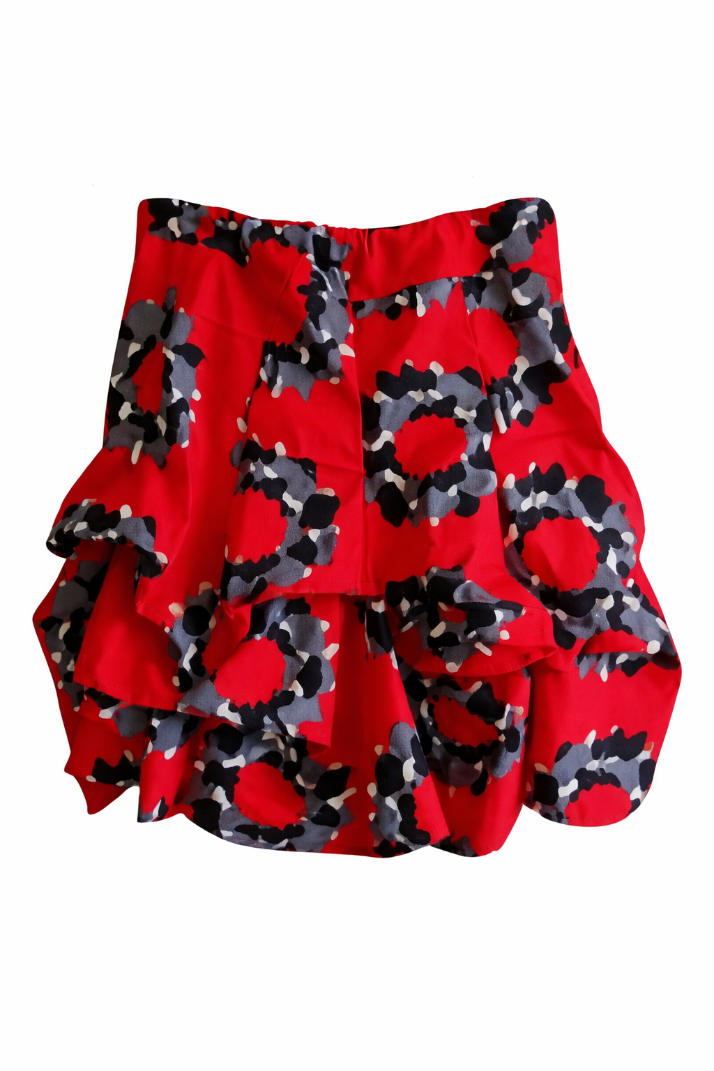 Short ruffled African wax skirt in red, black and grey floral circular print, handcrafted – product photo on white background.