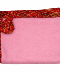 Baby blanket with soft pink fleece center and red African wax border, folded neatly with a matching decorative corner.