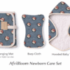 AfriBloom Newborn Care Set with hooded baby towel, changing mat and burp cloth in matching African wax fabric on white background