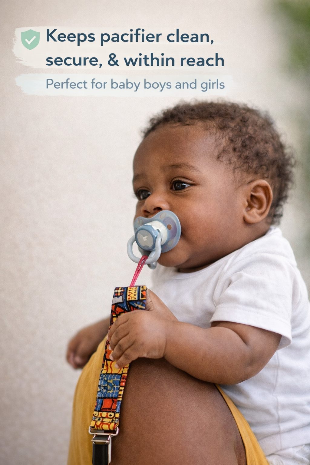 African print pacifier holder clip in use on baby – handmade wax fabric baby pacifier strap for newborns and infants