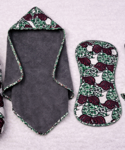 Newborn baby using African print swaddle and essentials bundle handmade in Belgium African print newborn essentials bundle including swaddle hooded towel burp cloth and animal blanky