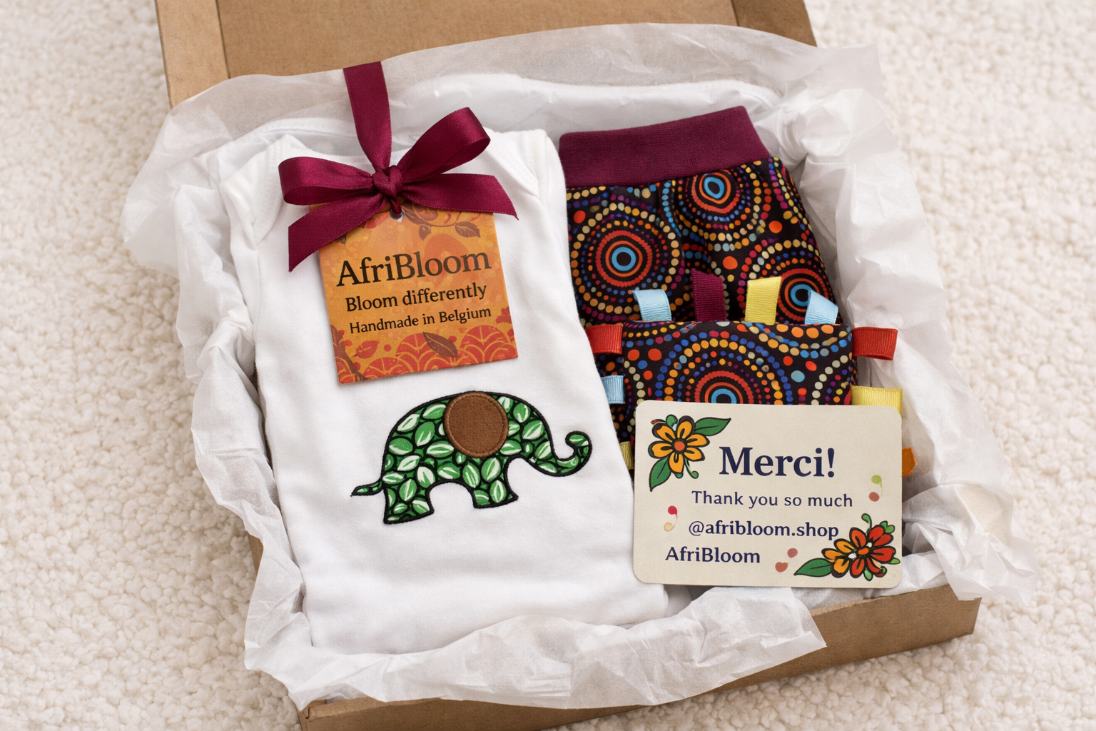 AfriBloom baby gift set in gift box with elephant appliqué onesie, African print pants and sensory crinkle toy