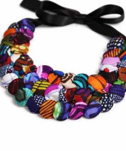 Close-up of handmade African statement necklace with colorful wax print fabric buttons and ribbon tie